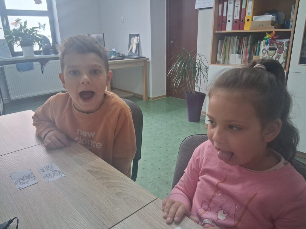 Ćwiczenia artykulacyjne zgodnie z wylosowany obrazkiem dzieci wykonują konkretne ćwiczenie