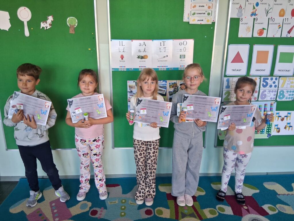 Dzieci z przedszkola pokazują certyfikaty  